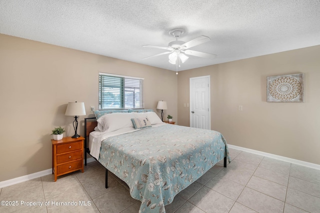 bedroom featuring a textured ceiling, light tile patterned flooring, and baseboards