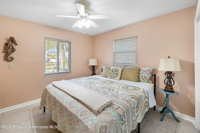 bedroom featuring light tile patterned flooring, a textured ceiling, and baseboards