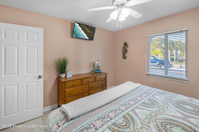 bedroom with tile patterned flooring, ceiling fan, and baseboards