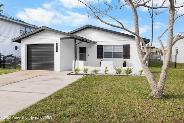 view of front facade with stucco siding, concrete driveway, an attached garage, fence, and a front lawn