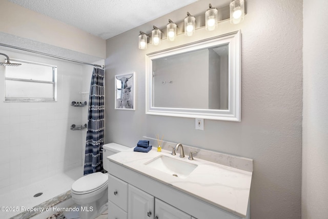 bathroom with toilet, a tile shower, a textured ceiling, and vanity