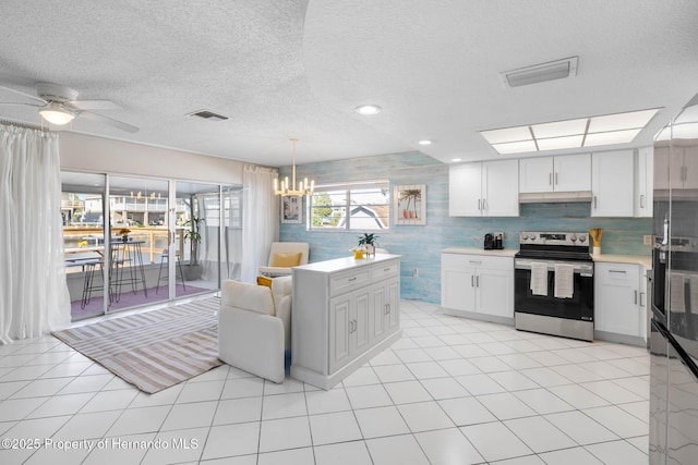 kitchen featuring light countertops, electric range, visible vents, and under cabinet range hood