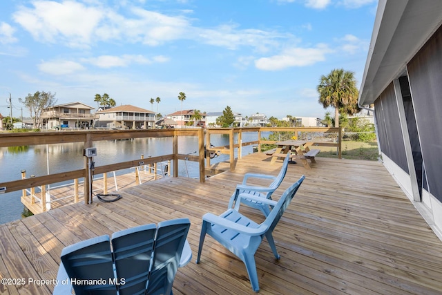 view of dock with a residential view and a water view