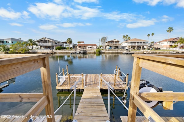 dock area featuring a water view, boat lift, and a residential view