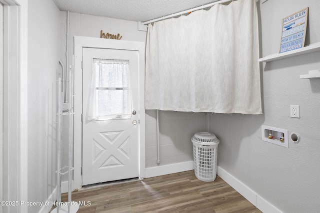 clothes washing area featuring laundry area, baseboards, wood finished floors, a textured ceiling, and washer hookup