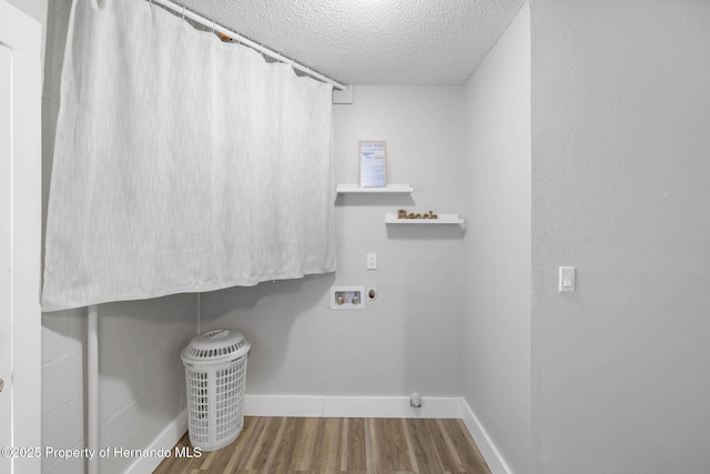 laundry area featuring laundry area, baseboards, wood finished floors, hookup for a washing machine, and a textured ceiling