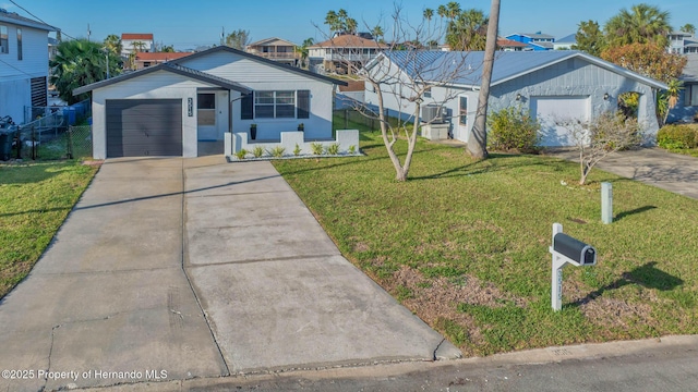 ranch-style house featuring concrete driveway, a front lawn, an attached garage, and fence