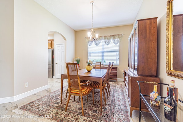 dining space featuring baseboards, arched walkways, marble finish floor, vaulted ceiling, and a chandelier