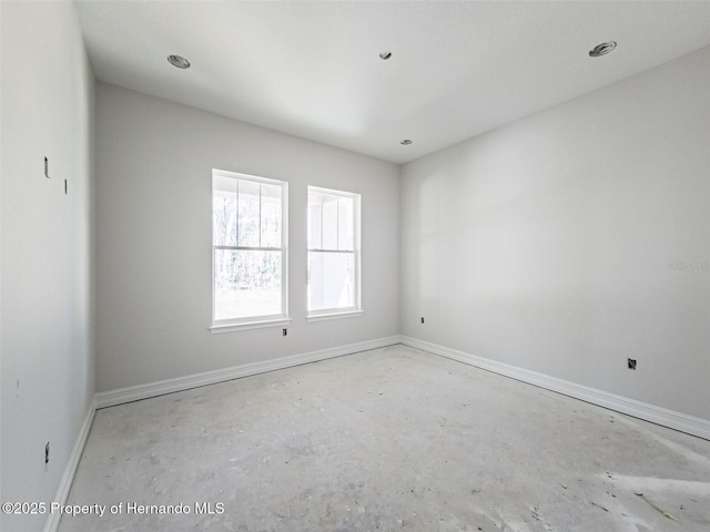 unfurnished room with baseboards