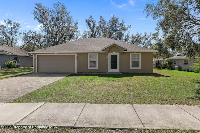 view of front of home with an attached garage, central air condition unit, decorative driveway, stucco siding, and a front lawn