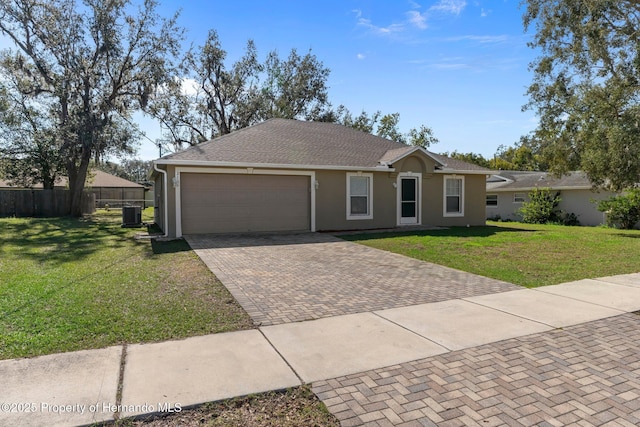 ranch-style house with a garage, a front yard, decorative driveway, and fence