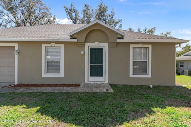 view of front of property with a front yard, roof with shingles, cooling unit, and stucco siding