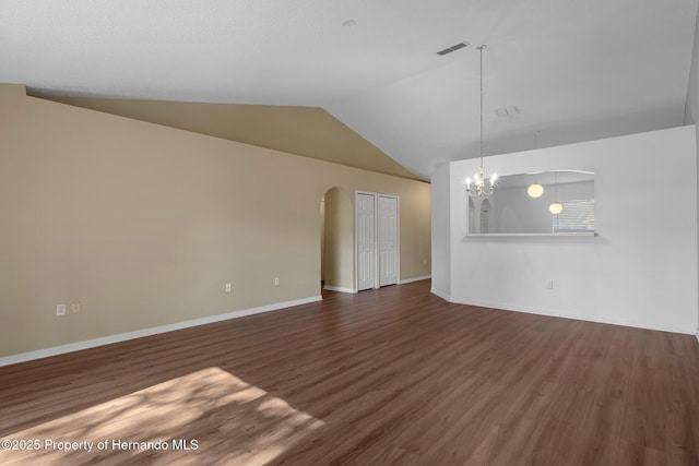 interior space with an inviting chandelier, arched walkways, vaulted ceiling, and dark wood-style flooring