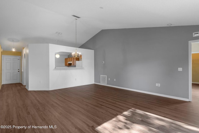 unfurnished living room featuring a chandelier, vaulted ceiling, wood finished floors, and visible vents