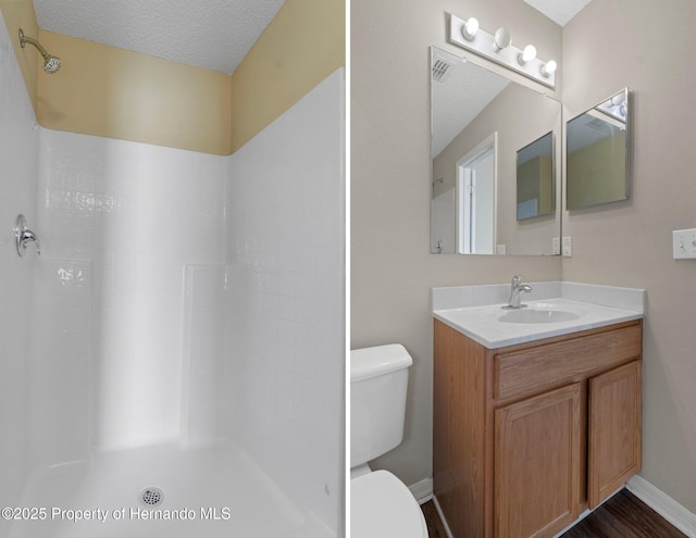 full bath with baseboards, toilet, walk in shower, a textured ceiling, and vanity