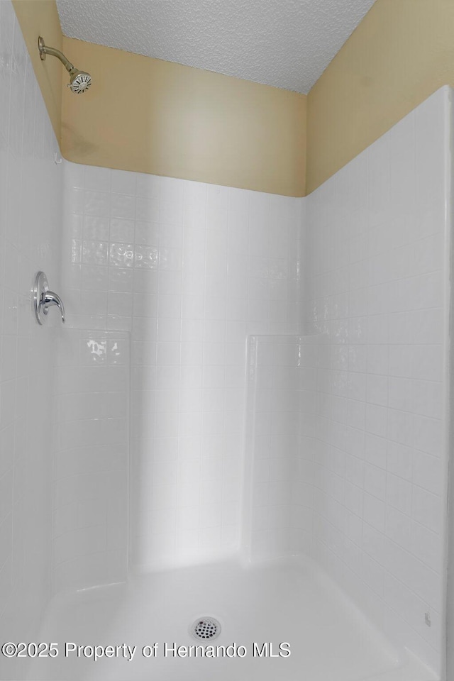 full bathroom with a textured ceiling and walk in shower