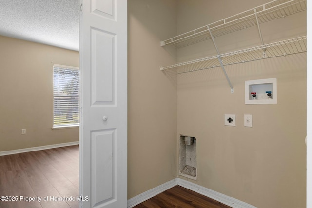 clothes washing area featuring laundry area, dark wood finished floors, electric dryer hookup, and baseboards