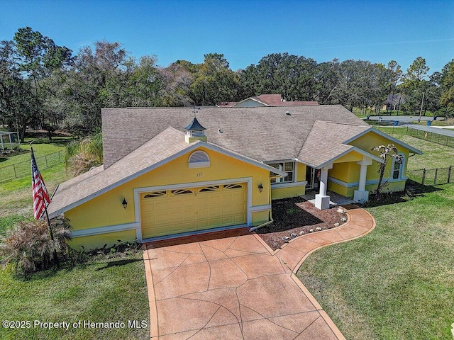 view of front of home featuring a garage, fence, driveway, stucco siding, and a front yard