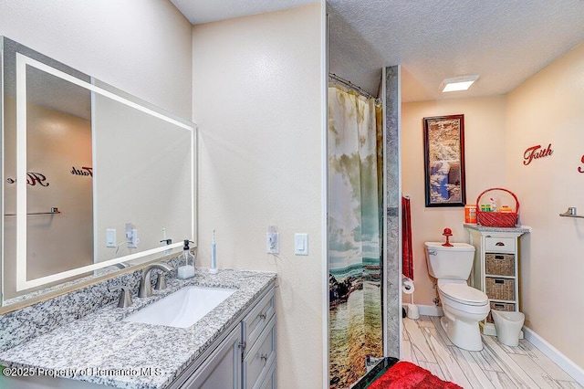 full bathroom with curtained shower, toilet, a textured ceiling, vanity, and baseboards