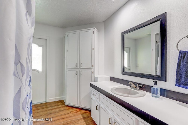 bathroom featuring a textured ceiling, wood finished floors, and vanity