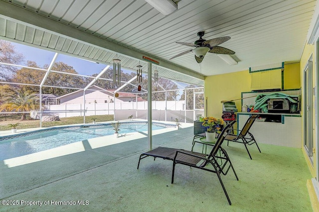 view of swimming pool with a lanai, a patio area, and fence