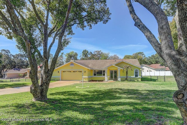 view of front of home with fence, driveway, a front lawn, and stucco siding