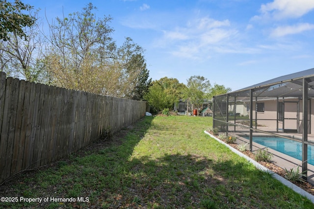 view of yard featuring a fenced in pool, glass enclosure, and a fenced backyard