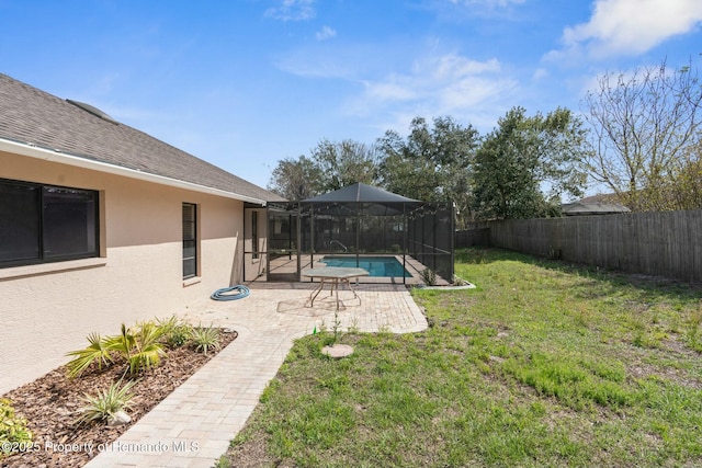 view of yard featuring a patio, a fenced backyard, glass enclosure, and a fenced in pool