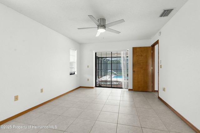 unfurnished room featuring ceiling fan, light tile patterned floors, visible vents, and baseboards