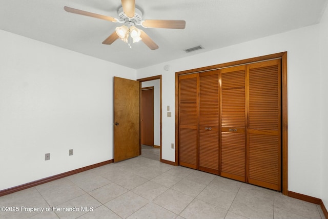 unfurnished bedroom with a closet, visible vents, light tile patterned flooring, ceiling fan, and baseboards