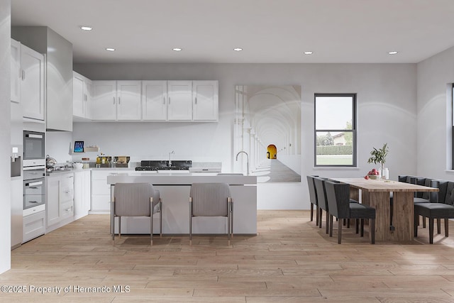 kitchen with white oven, light wood-style flooring, white cabinets, and oven