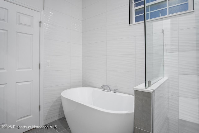 full bath featuring tile walls, a soaking tub, and a tile shower