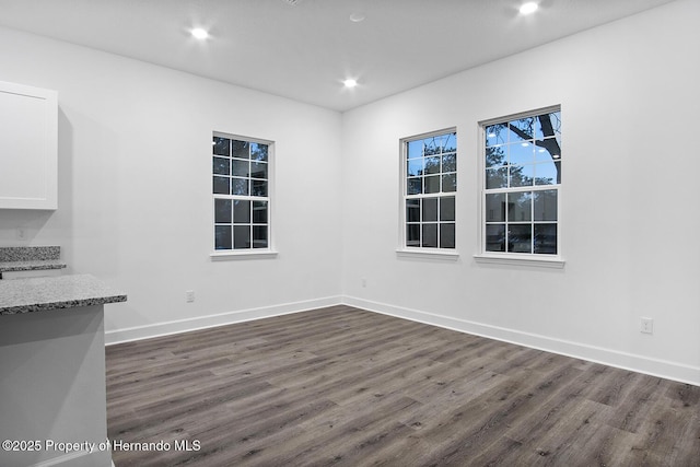 unfurnished dining area with recessed lighting, baseboards, and dark wood-style flooring