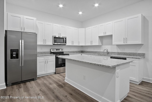 kitchen with a kitchen island, white cabinetry, and stainless steel appliances