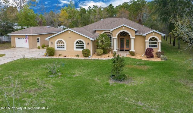 view of front of property featuring a front yard, french doors, driveway, and stucco siding