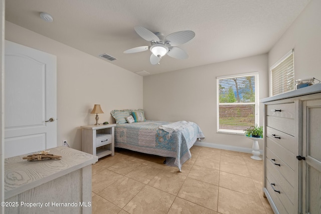 bedroom with a ceiling fan, visible vents, baseboards, and light tile patterned floors