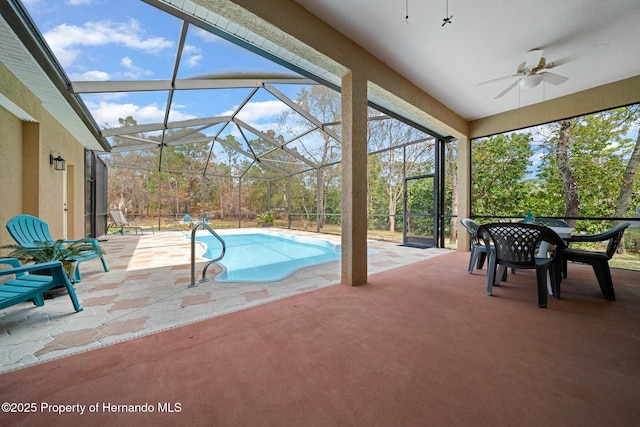 pool featuring a patio area, glass enclosure, and a ceiling fan