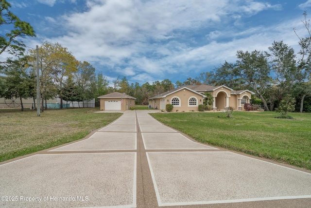 mediterranean / spanish home with an outbuilding, a front yard, fence, and a garage