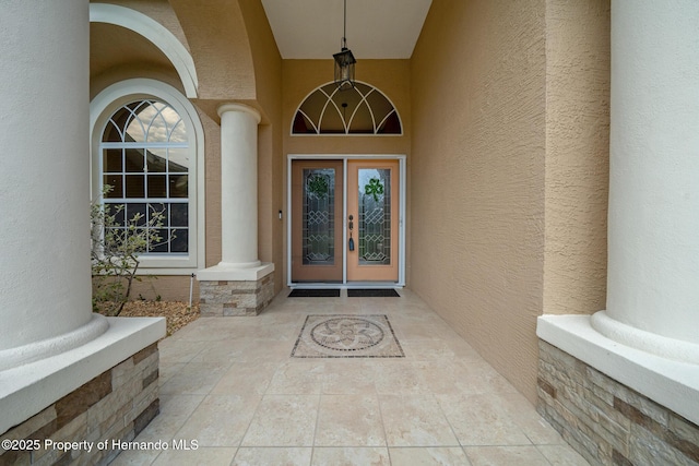 doorway to property featuring stucco siding