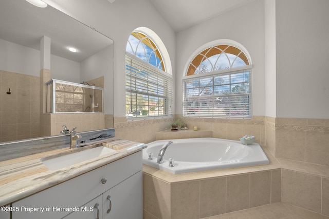 bathroom featuring vanity, a shower stall, and a bath