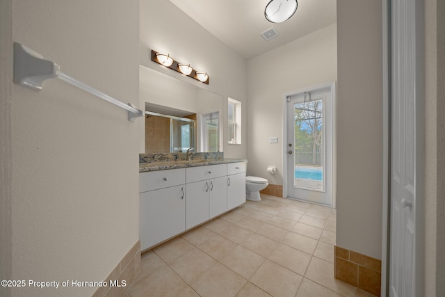 bathroom featuring visible vents, toilet, a tile shower, vanity, and tile patterned flooring