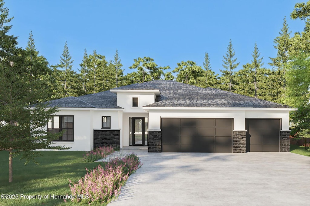 prairie-style house featuring an attached garage, driveway, and stucco siding