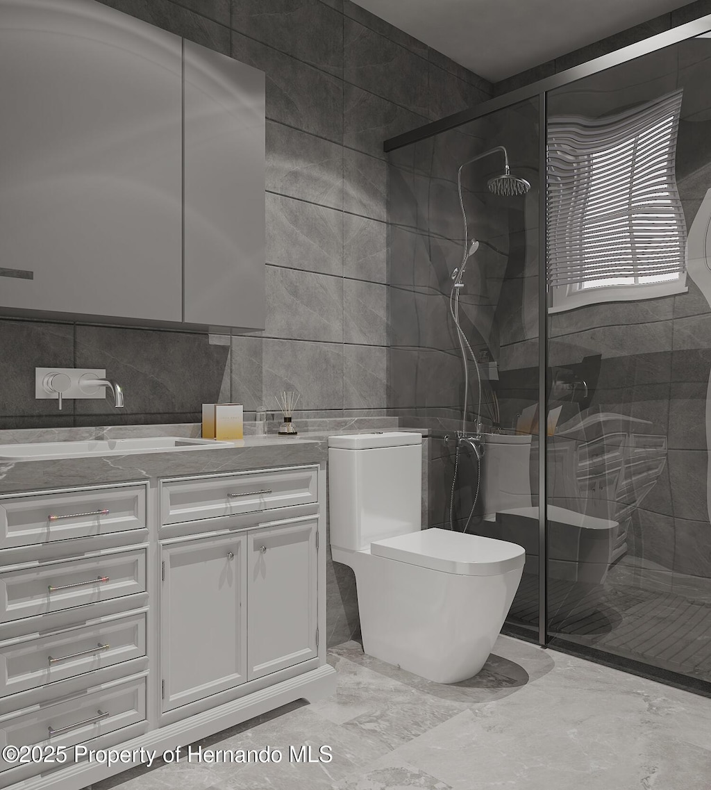 full bath with toilet, vanity, a stall shower, marble finish floor, and tile walls