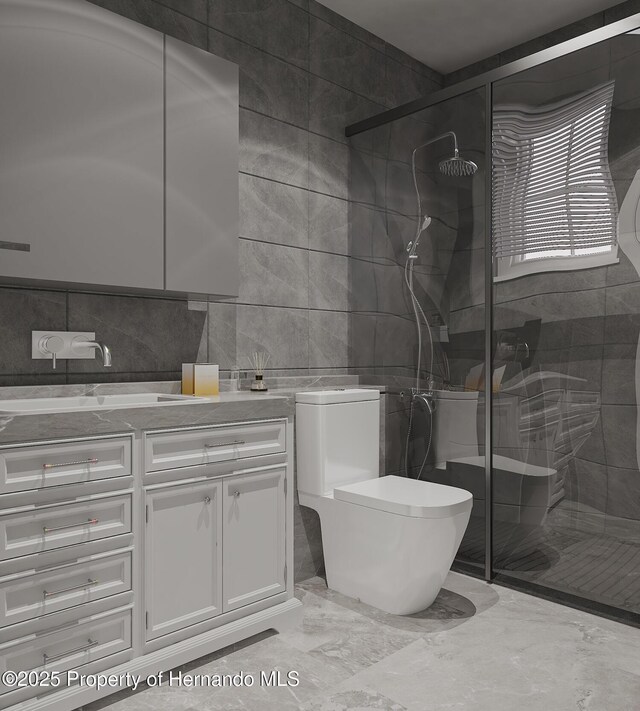 full bath with toilet, vanity, a stall shower, marble finish floor, and tile walls