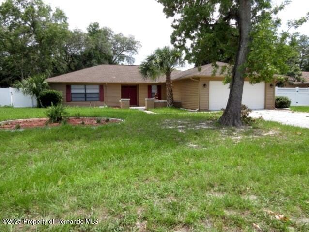 ranch-style house with a garage, fence, driveway, and a front lawn