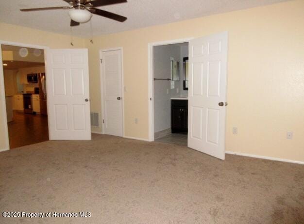 unfurnished bedroom with carpet flooring, visible vents, and baseboards