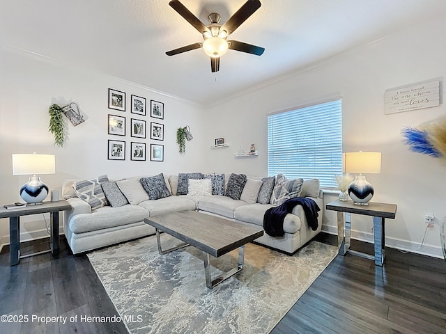 living area featuring baseboards, ornamental molding, ceiling fan, and wood finished floors