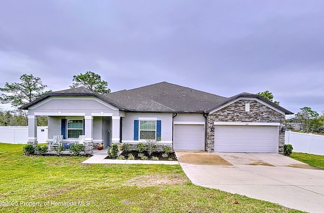 view of front of property featuring an attached garage, driveway, fence, and a front yard