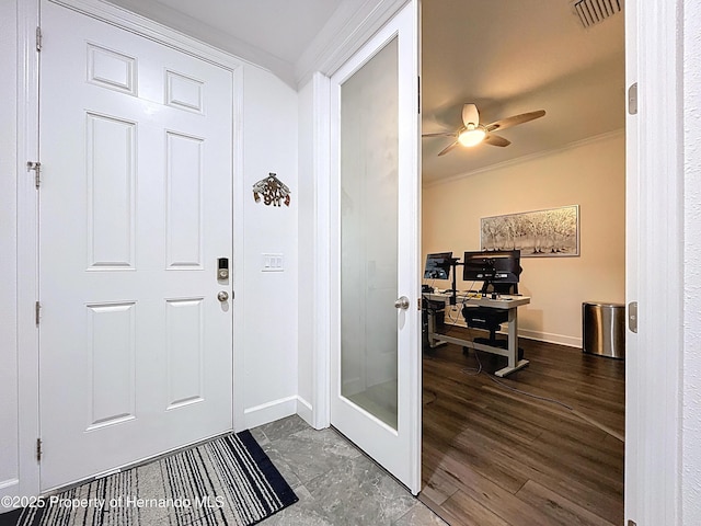 foyer entrance featuring visible vents, baseboards, ceiling fan, ornamental molding, and wood finished floors