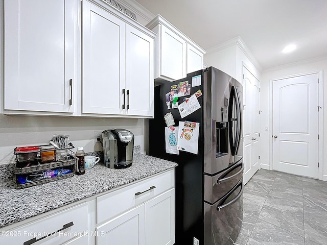 kitchen with white cabinets, stainless steel fridge with ice dispenser, marble finish floor, ornamental molding, and light stone countertops